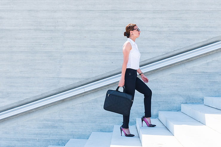Business woman looking up ready to climb the success staircase